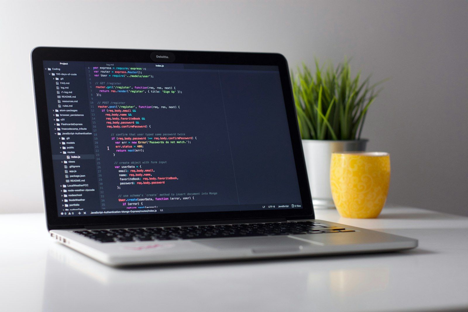 Software development workspace with code on laptop